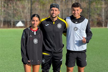 A group of young boys energetically playing soccer on an indoor field, showcasing teamwork and enthusiasm.